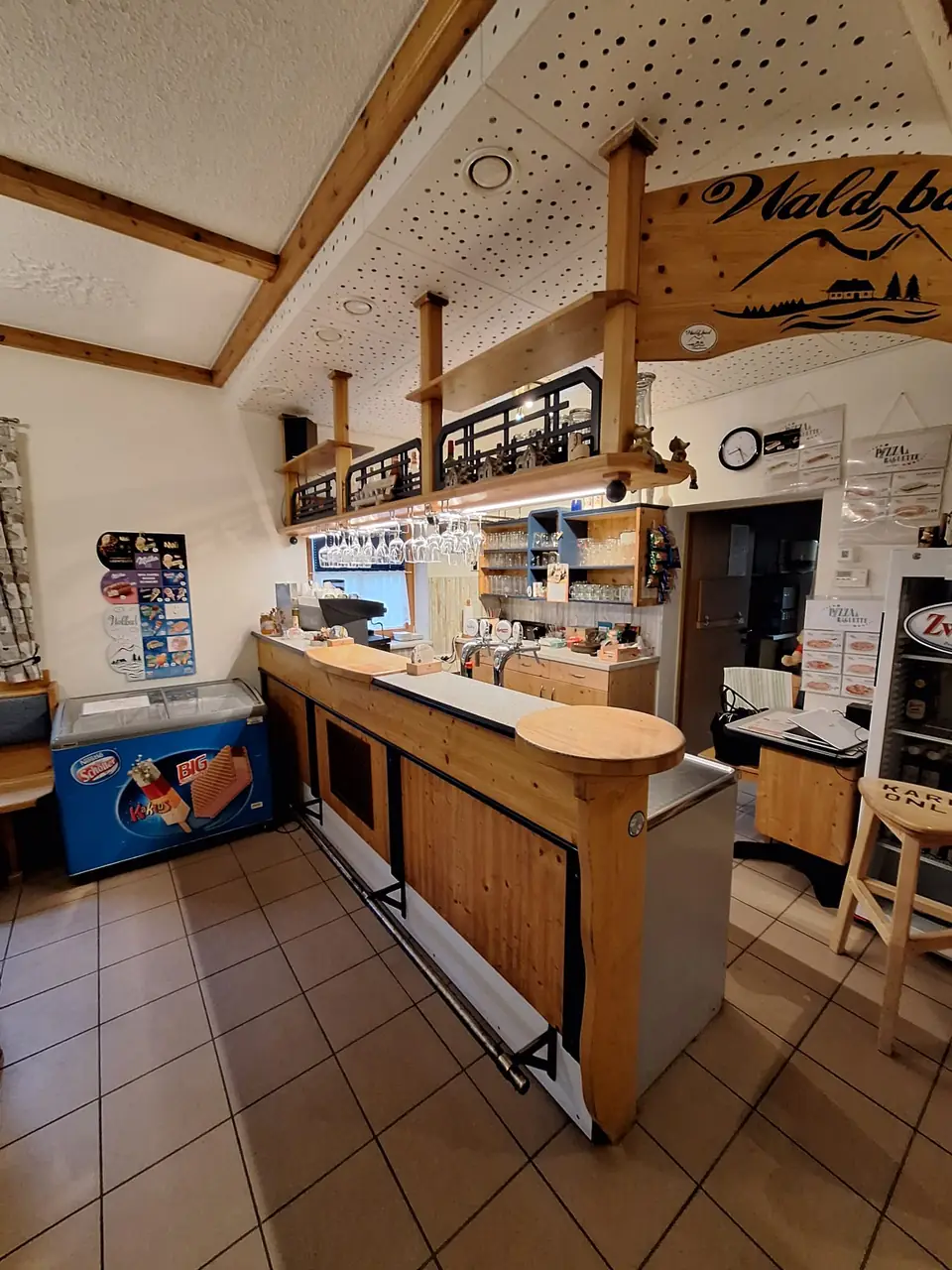 Holztheke des Waldbad-Buffets mit Zapfhähnen, Gläsern und Waldbad-Schild